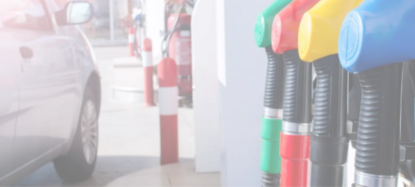 A fuel pump at a service station with a car waiting to fill up